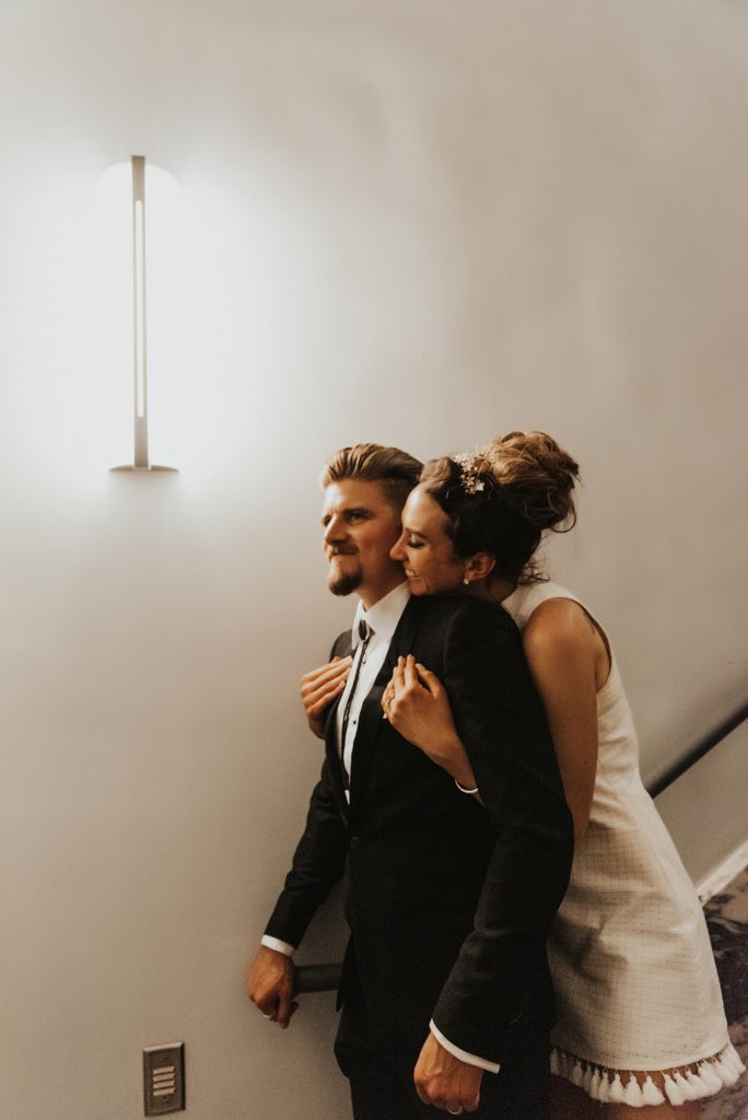 Bride hugging groom from behind