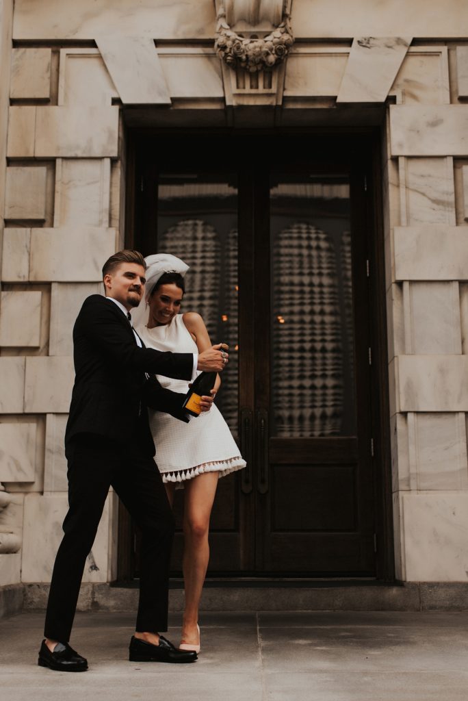 Bride and groom popping champagne on Le Meridien Tampa steps