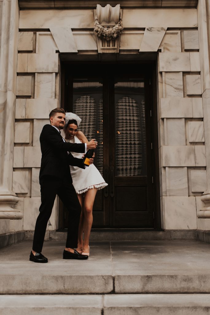 Bride and groom popping champagne on Le Meridien Tampa steps