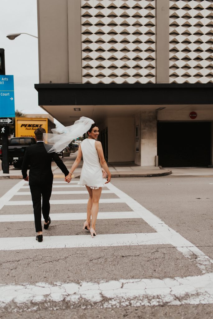 Bride and groom crossing downtown tampa street