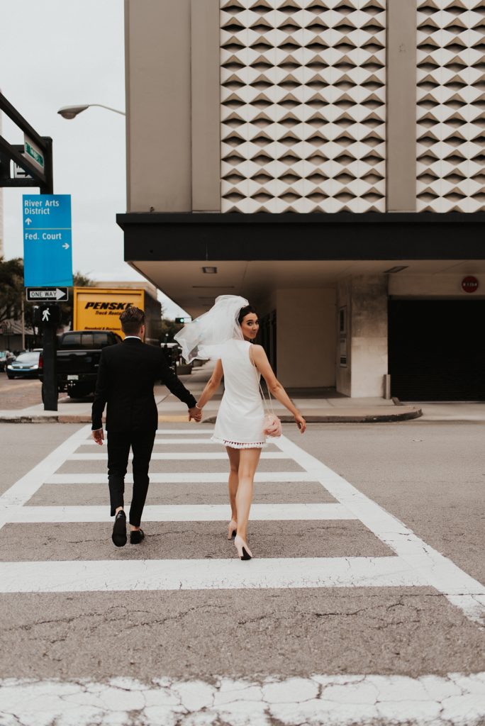 Bride and groom crossing downtown tampa street