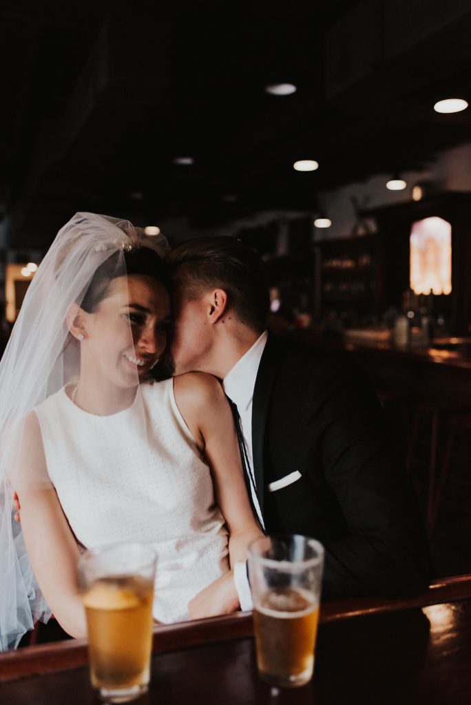 Groom whispering into brides ear