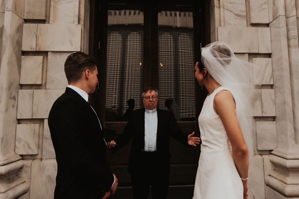 Pastor marrying bride and groom on front of Le meridien tampa steps