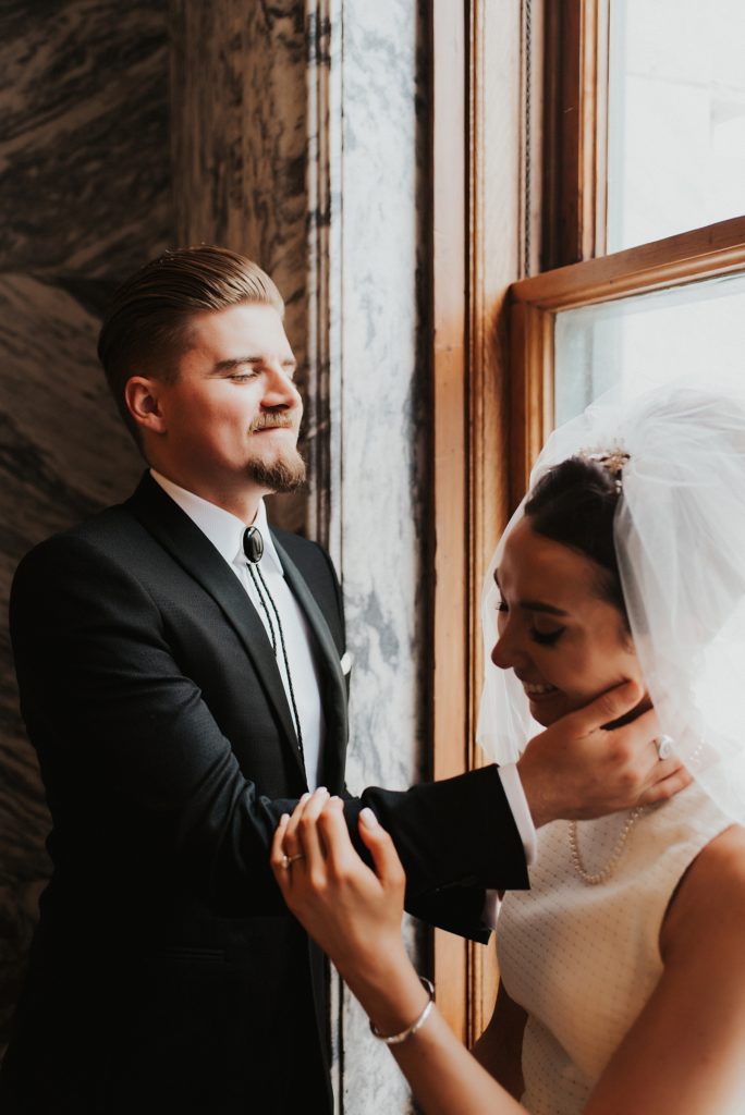 Groom holding brides neck and laughing