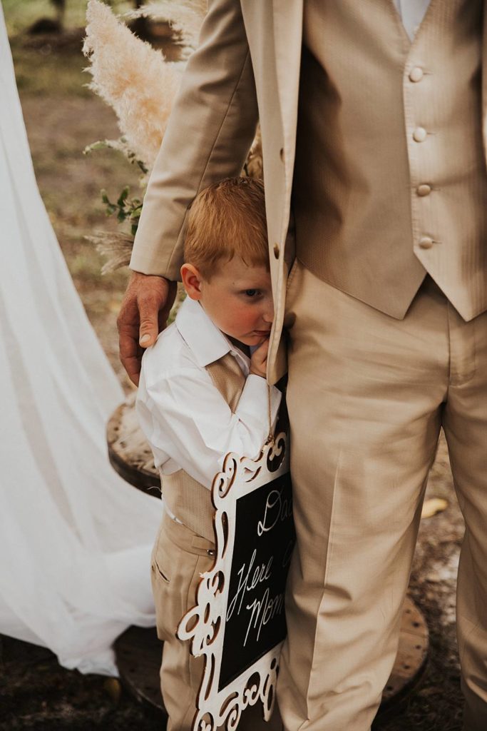 Ring bearer walking down the aisle during oak trees for okeechobee florida wedding ceremony