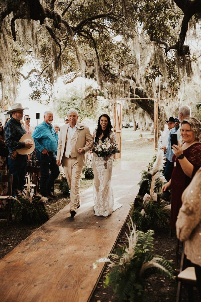 Bride walking down the aisle in an outdoor ceremony in okeechobee florida