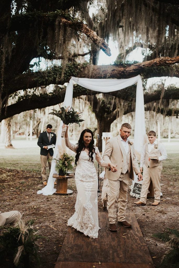 Bride and groom walking back down the aisle after getting married in outdoor ceremony in okeechobee florida