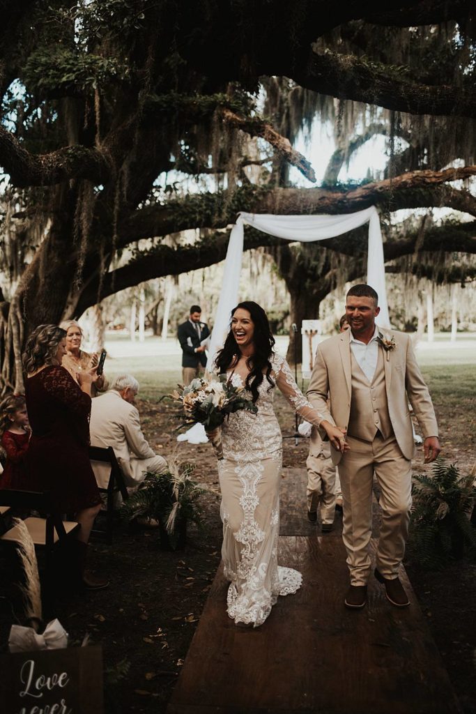 Bride and groom walking back down the aisle after getting married in outdoor ceremony in okeechobee florida