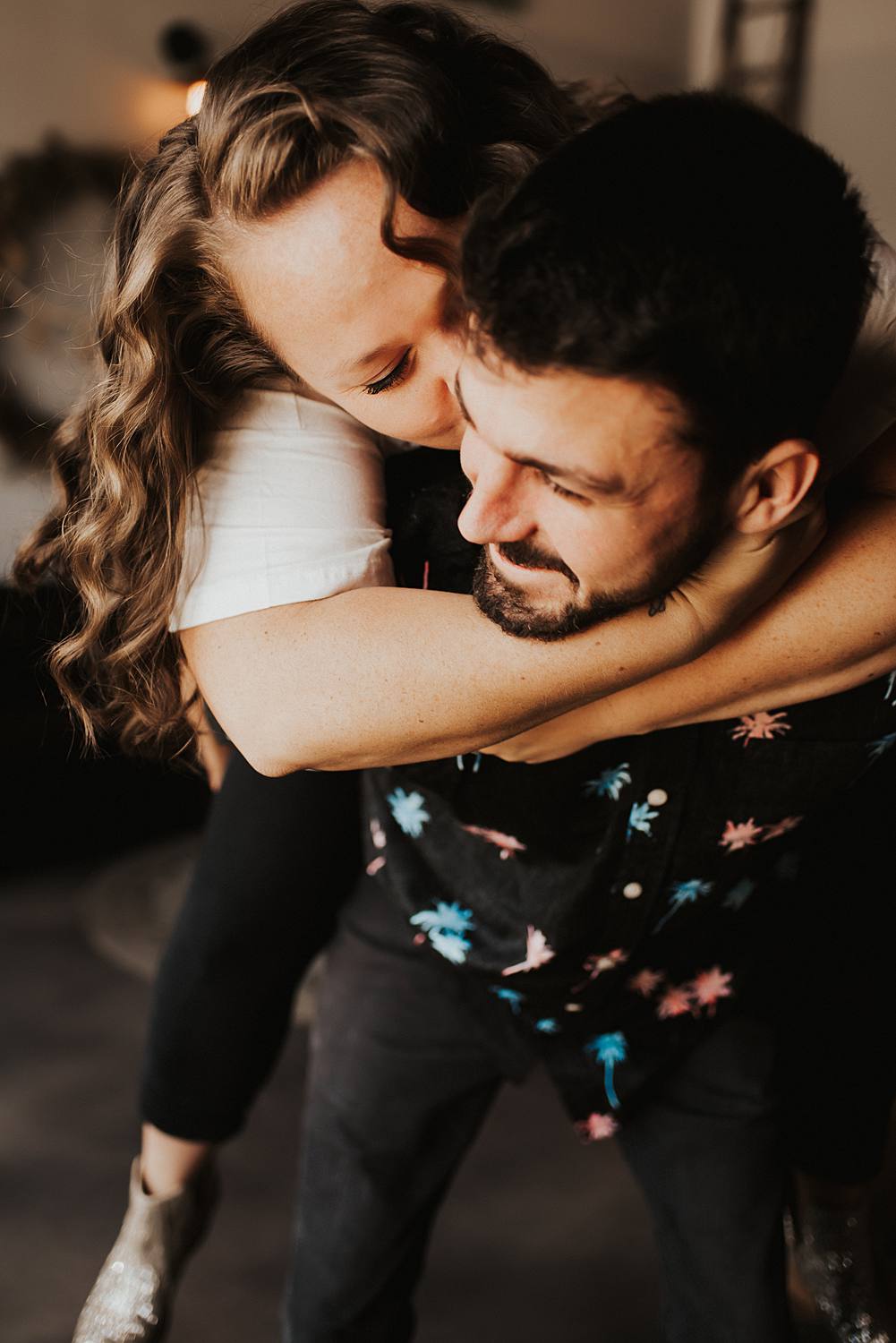 Couple giving piggy back ride during engagement session at brewery