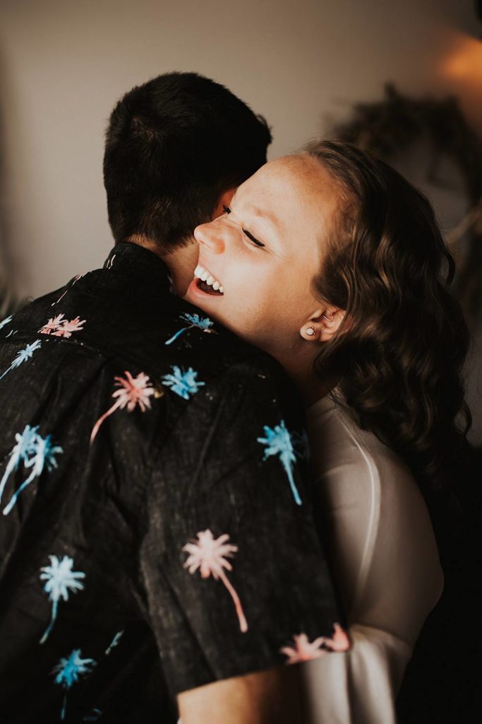 Couple laughing during engagement session at brewery