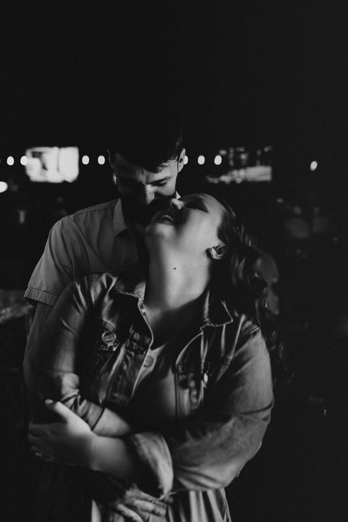 Couple hugging during engagement session inside brewery