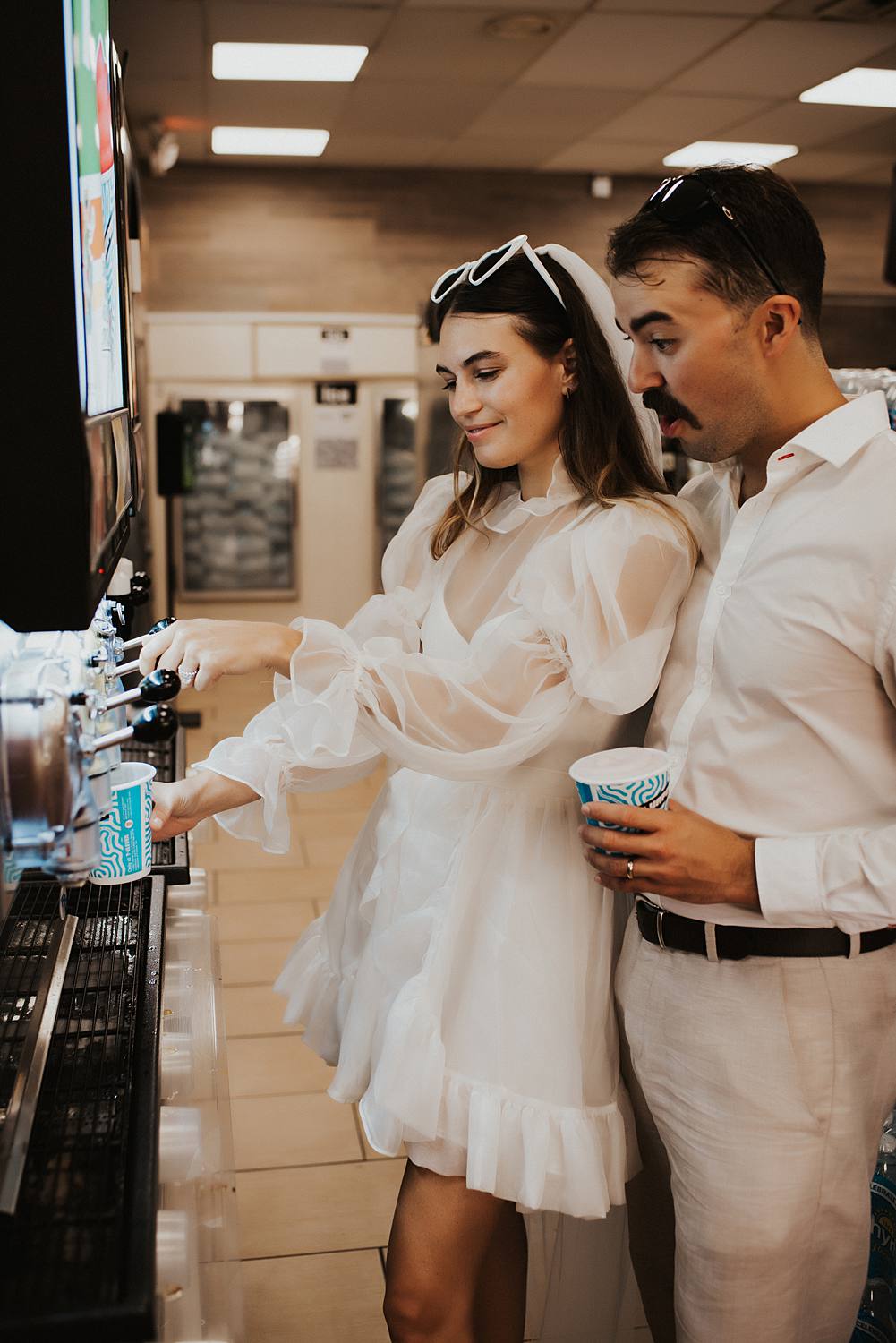 Bride and groom filling slurpie cups at 7 eleven