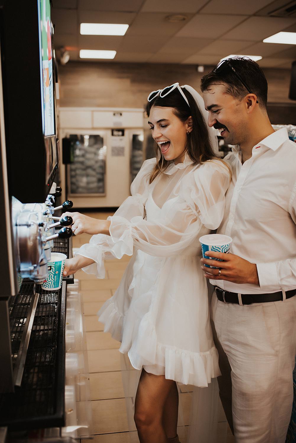 Bride and groom filling slurpie cups at 7 eleven