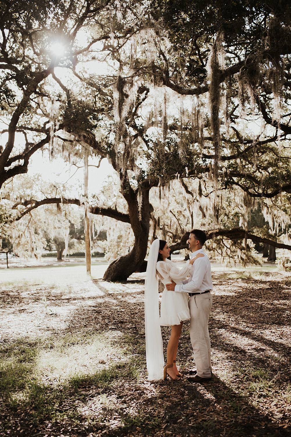 Bride and groom under oak trees