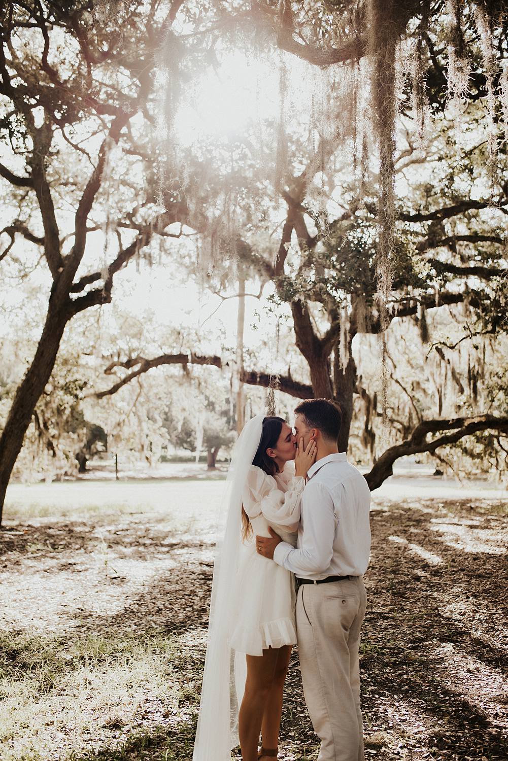 Bride and groom under oak trees