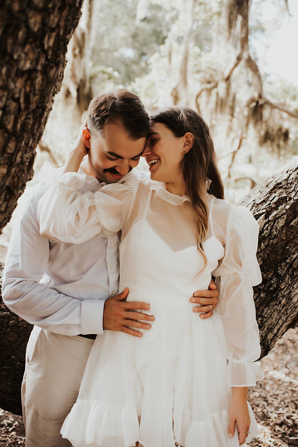 Bride and groom under oak trees