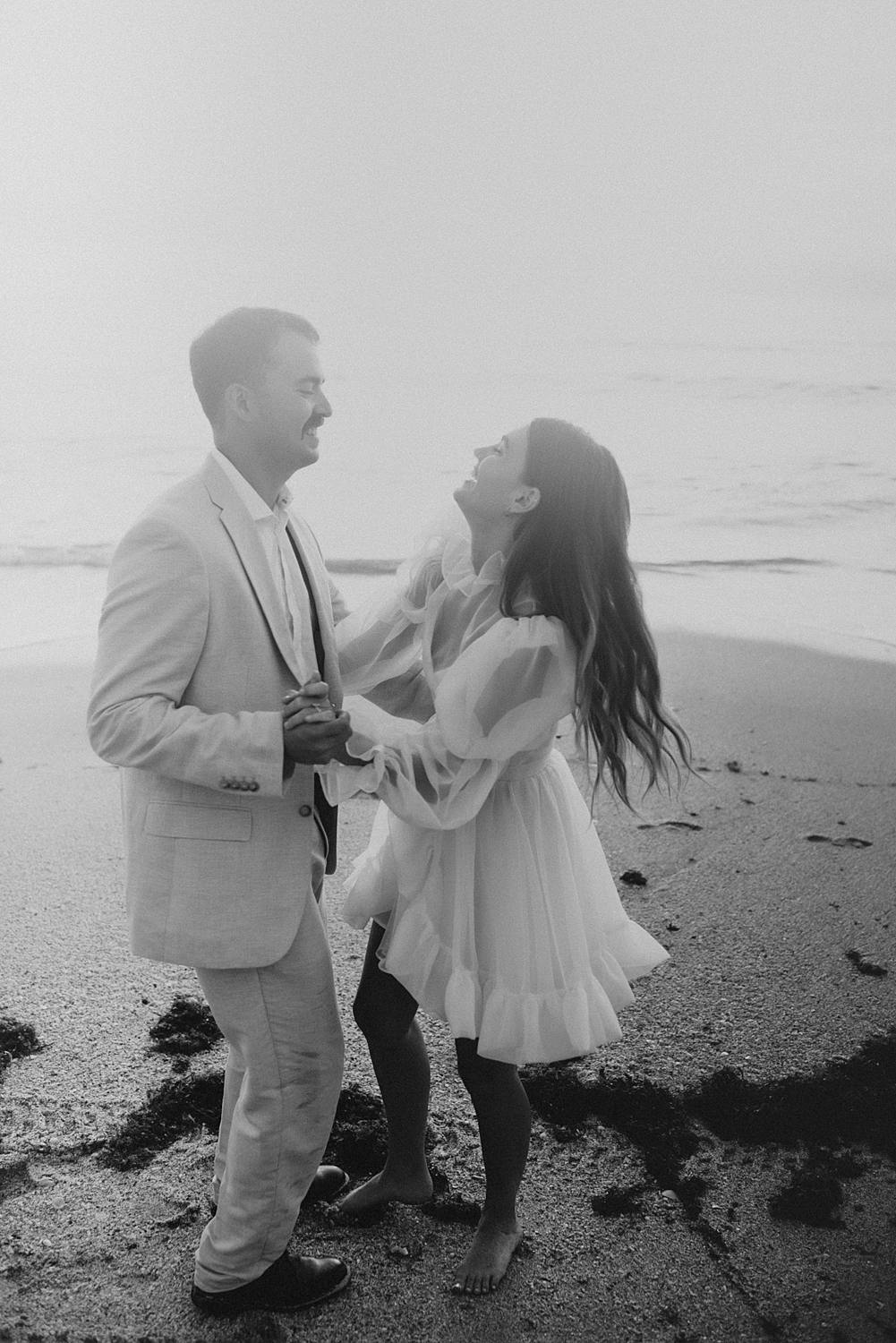 Bride and groom dancing on beach