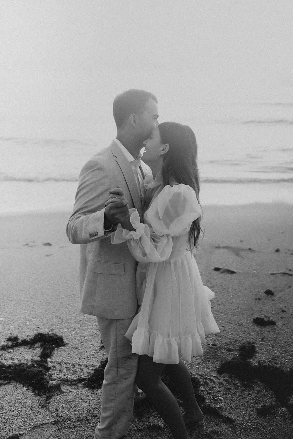Bride and groom dancing on beach