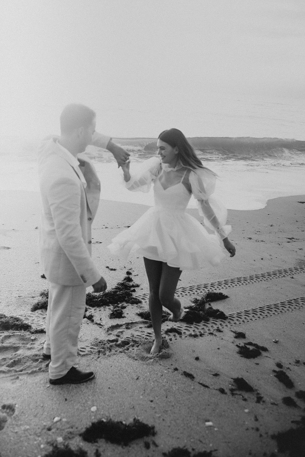 Bride and groom dancing on beach