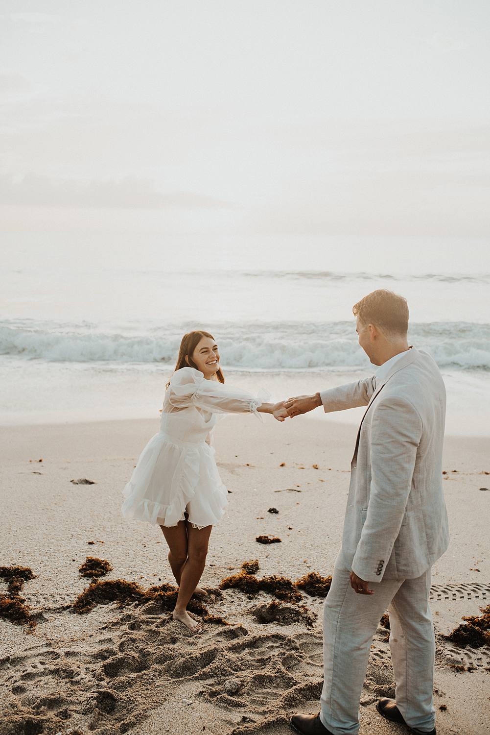 Bride and groom dancing on beach