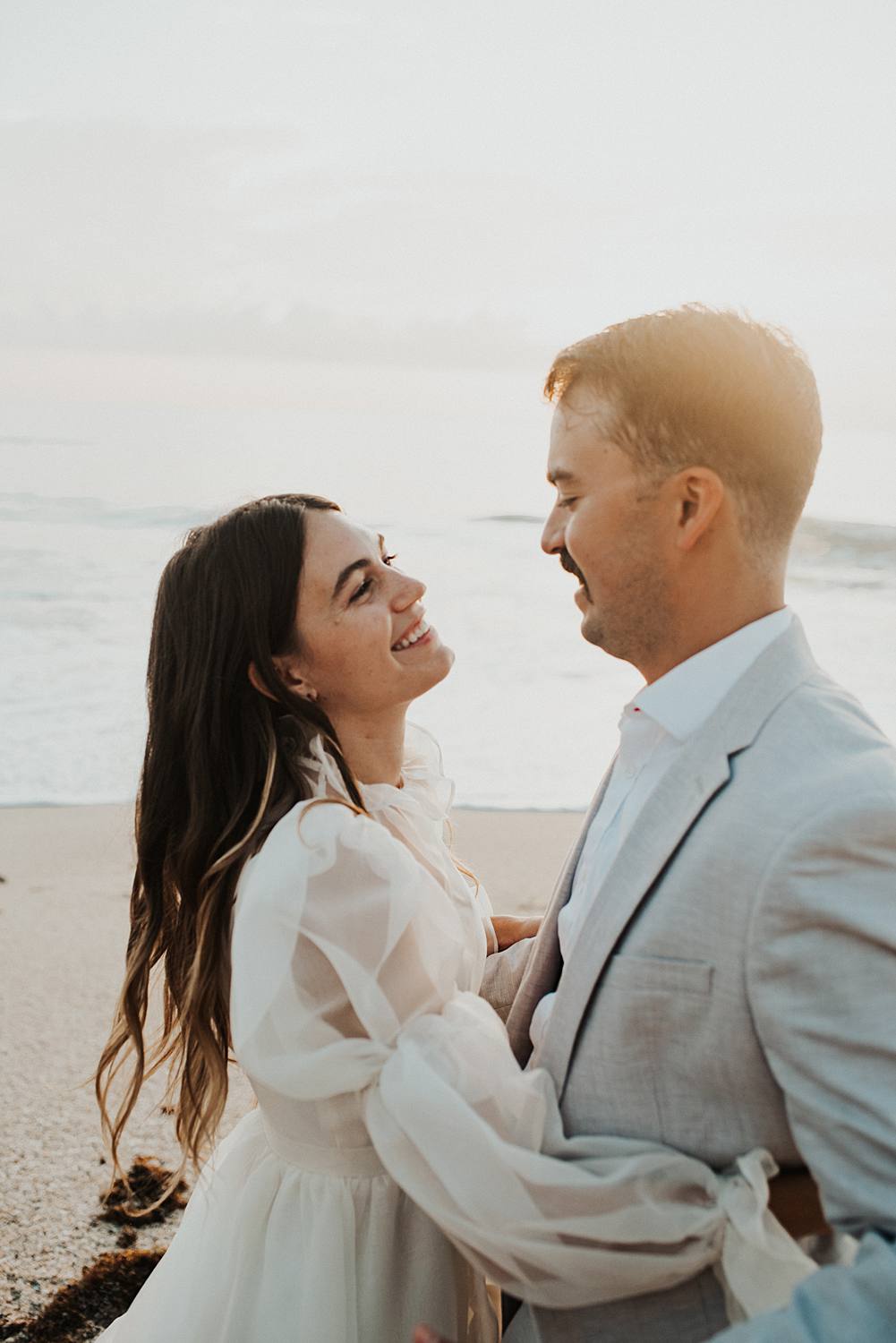 Bride and groom dancing on beach