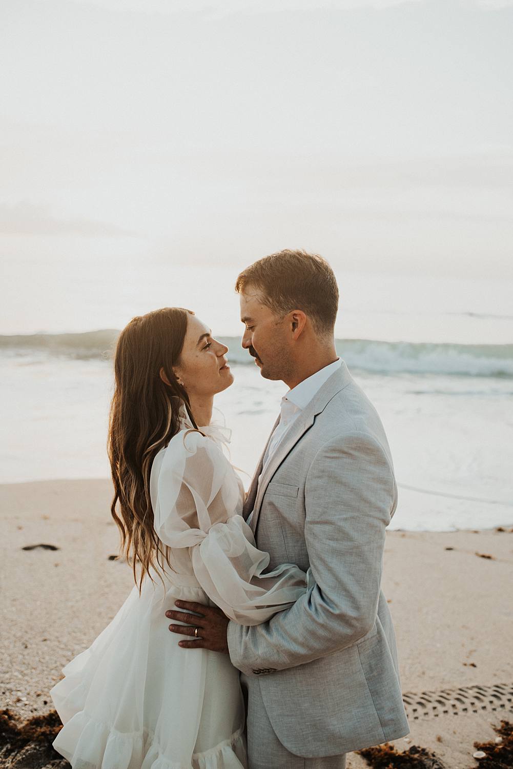 Bride and groom dancing on beach