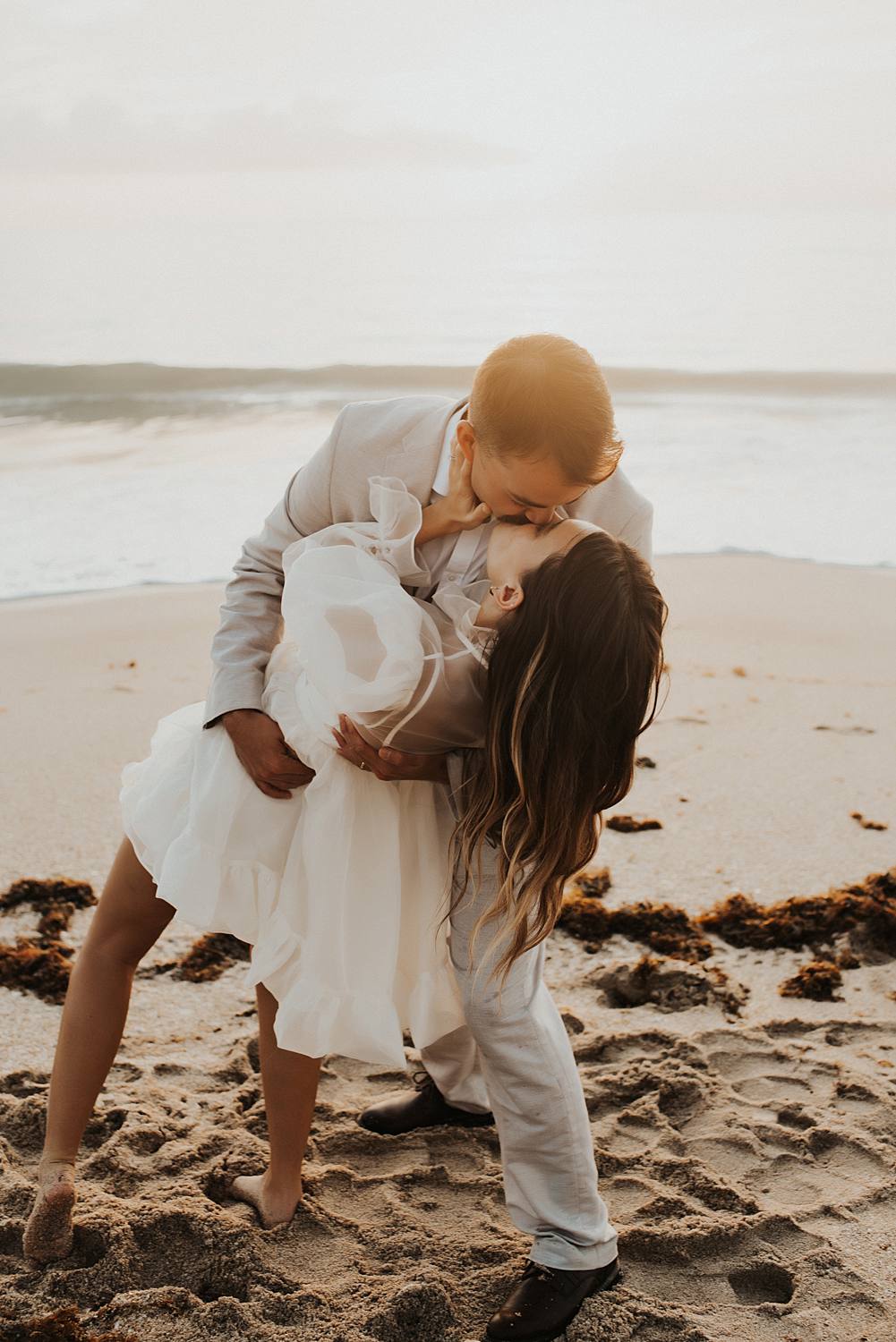 Bride and groom dancing on beach