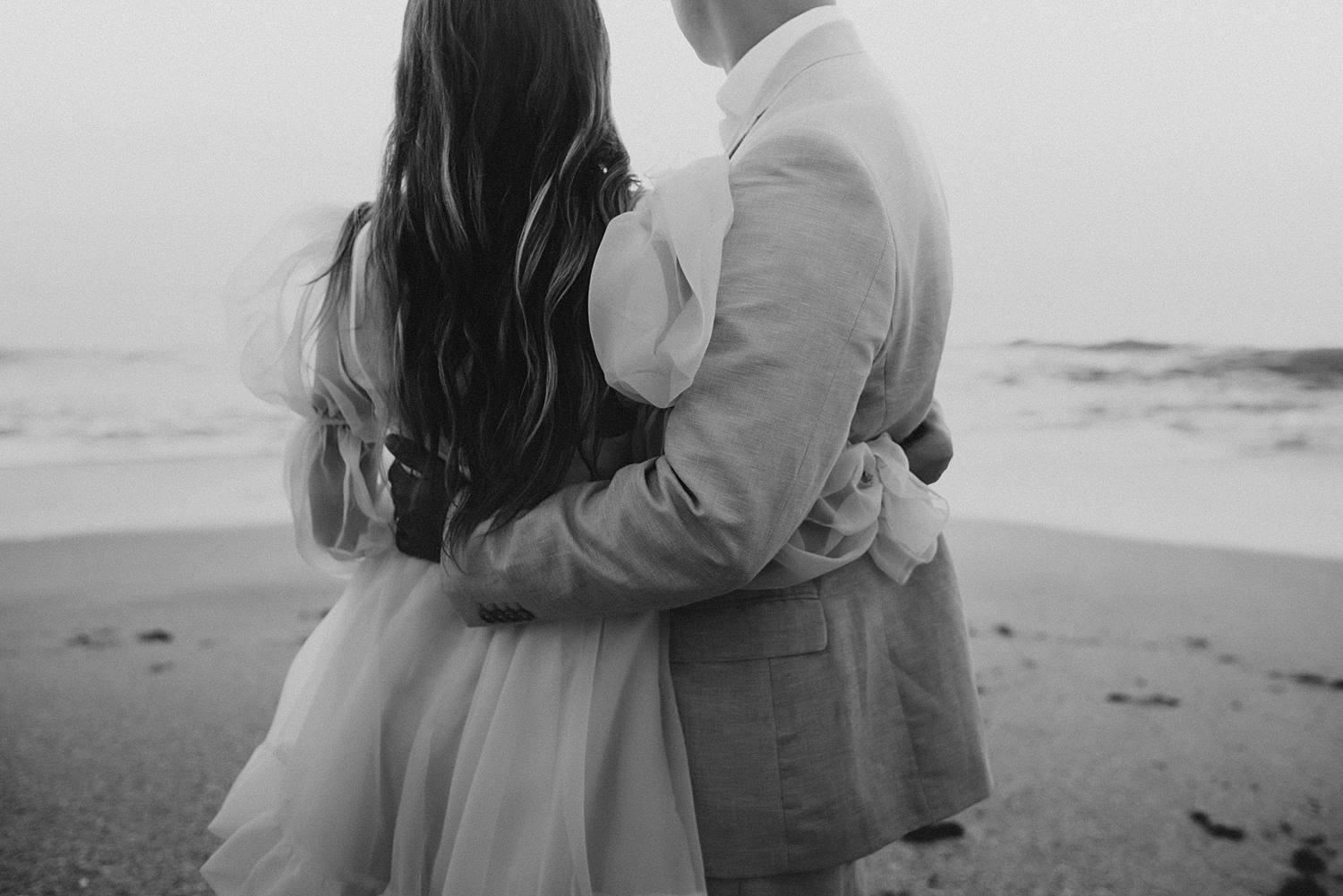 Bride and groom dancing on beach
