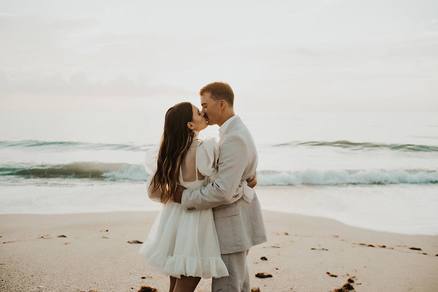Bride and groom dancing on beach