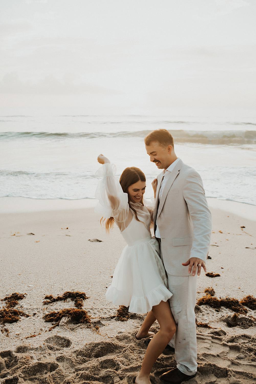 Bride and groom dancing on beach