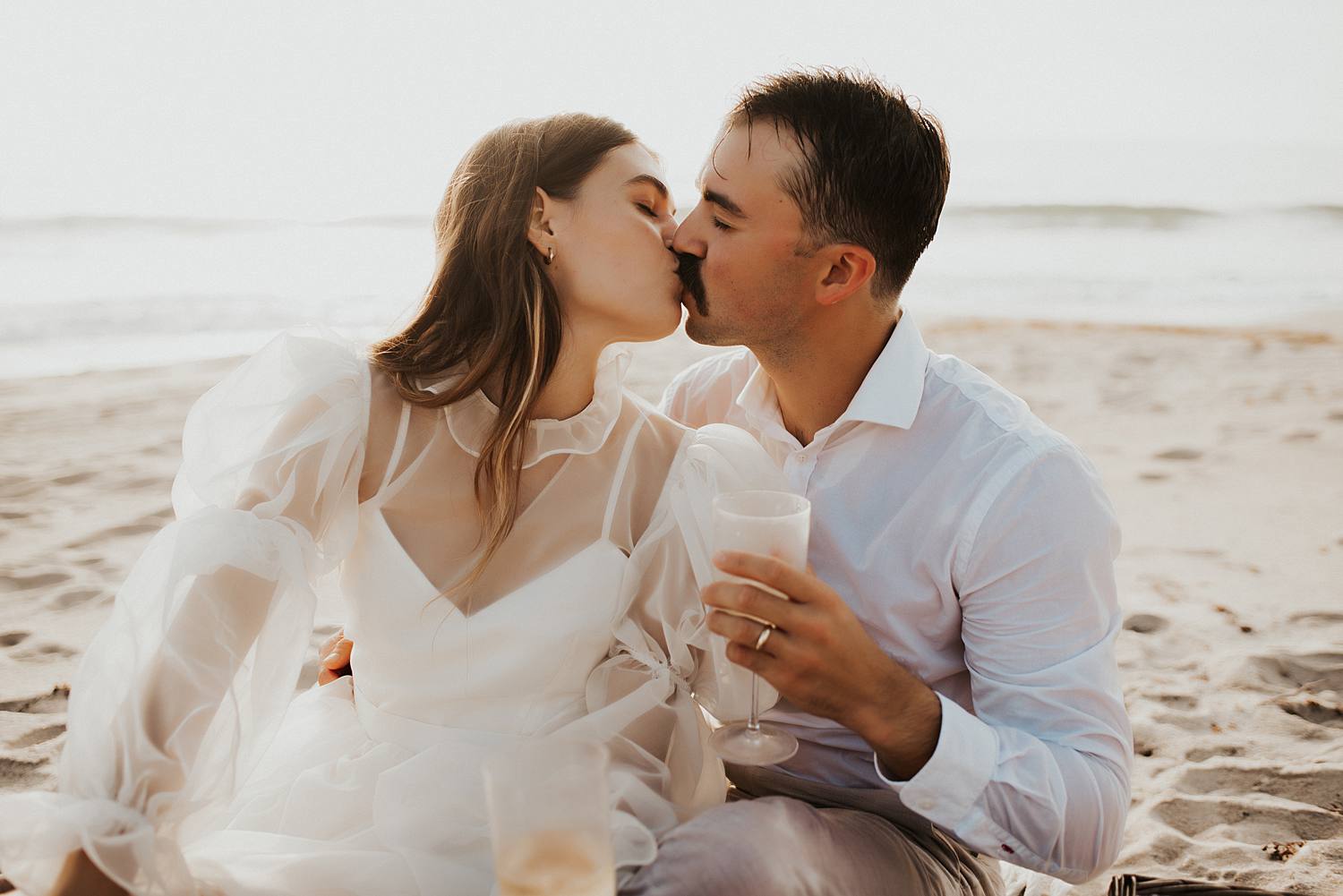 Groom pouring champagne during elopement picnic