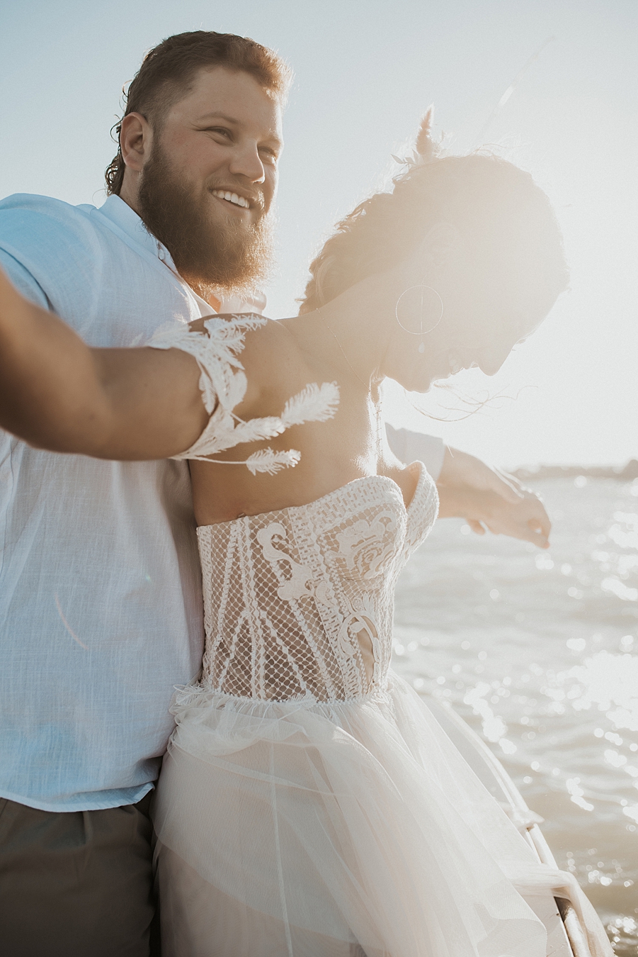 Groom hugging bride from behind on boat