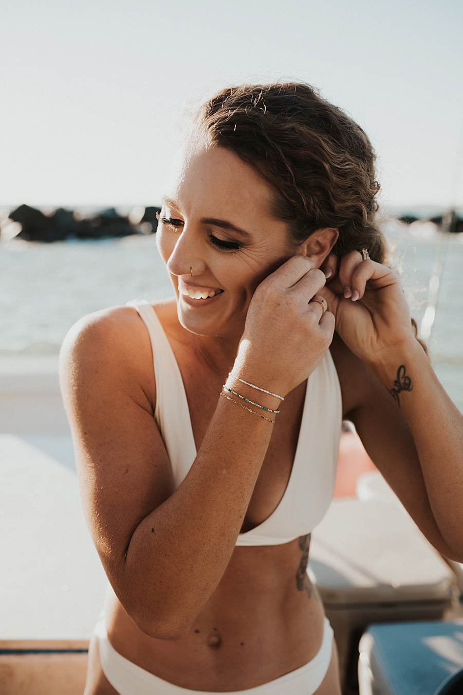 Bride in bikini putting on earrings