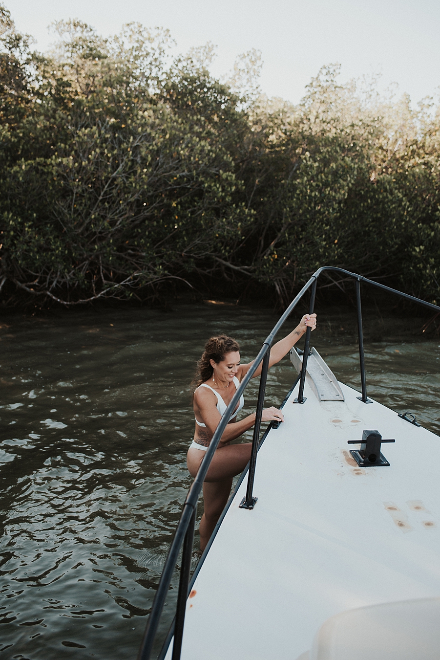 Bride climbing off boat during elopement