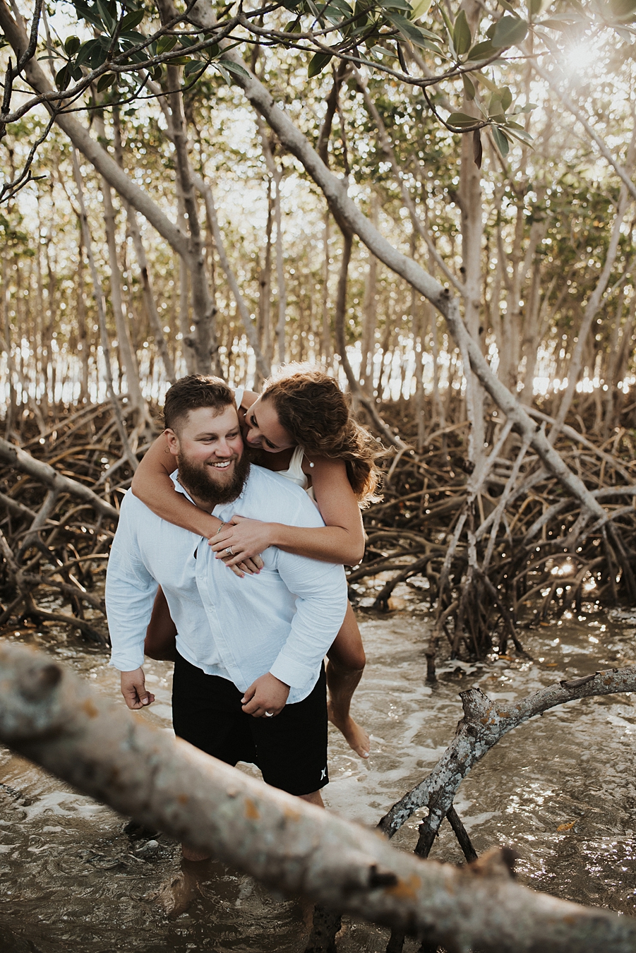 Bride on groom's back in mangrove trees
