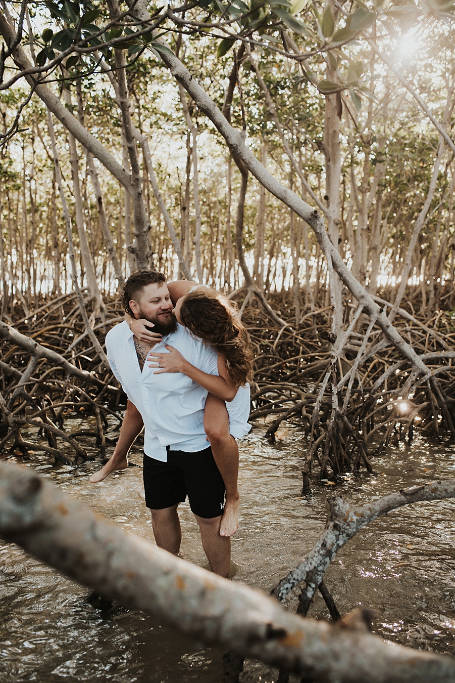 Bride on groom's back in mangrove trees