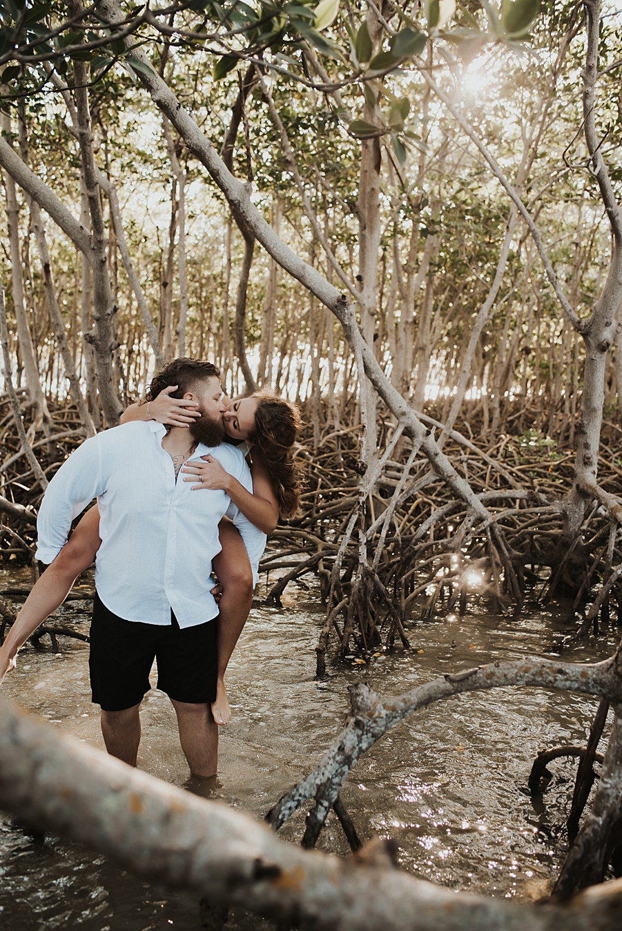 Bride on groom's back in mangrove trees