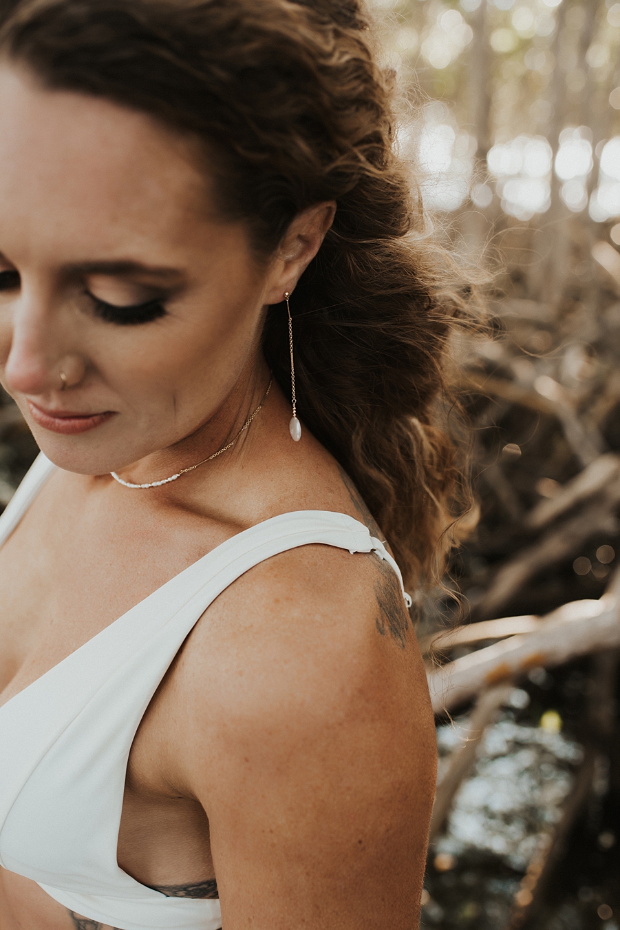 Classic makeup on bride in bikini with drop earrings