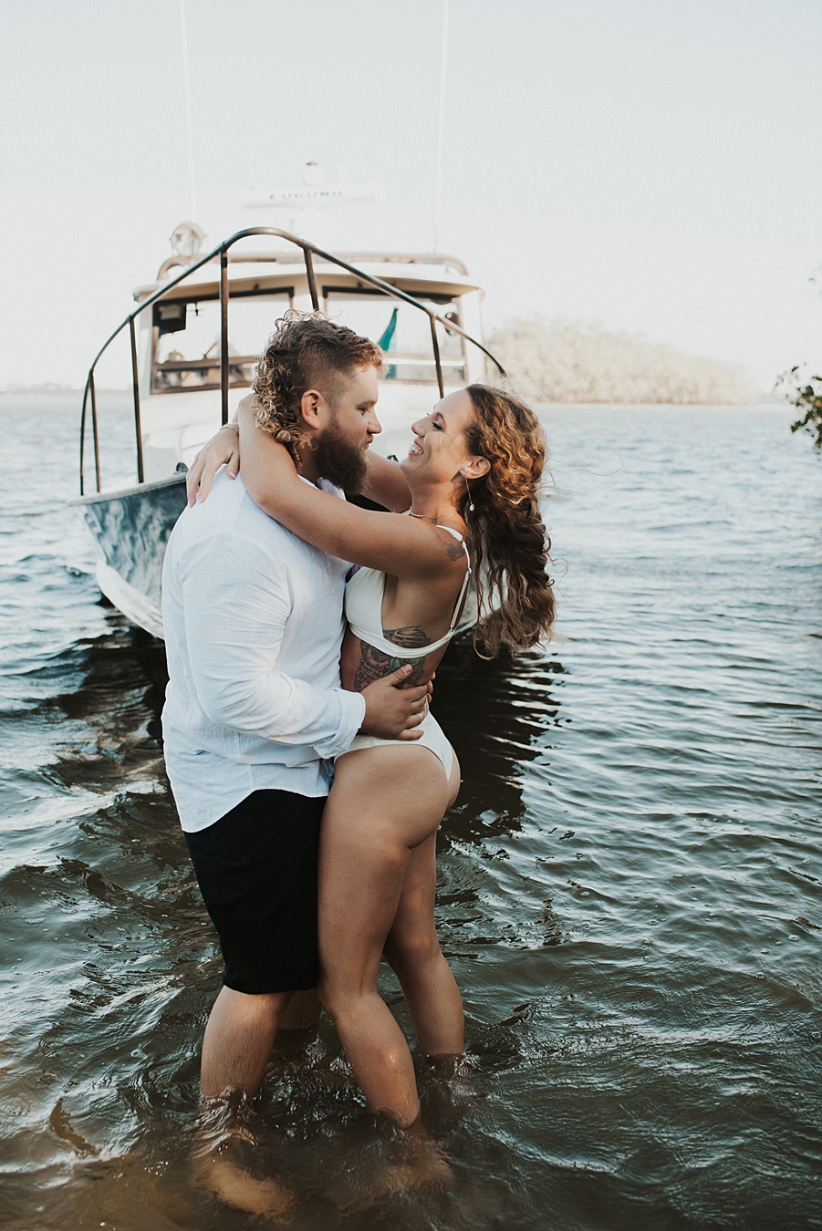 Bride and groom posing in front of fishing boat