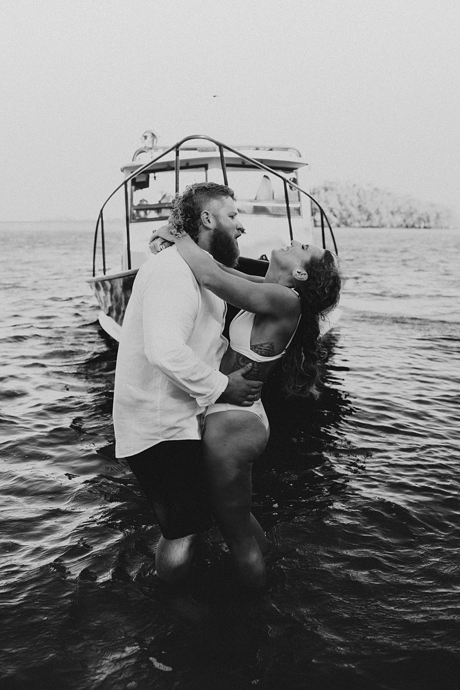 Bride and groom posing in front of fishing boat