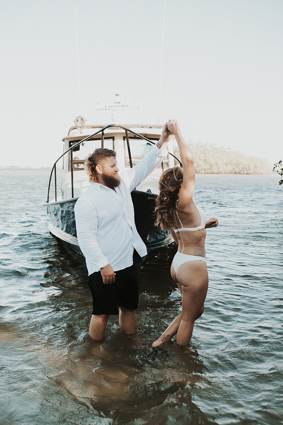 Bride and groom posing in front of fishing boat