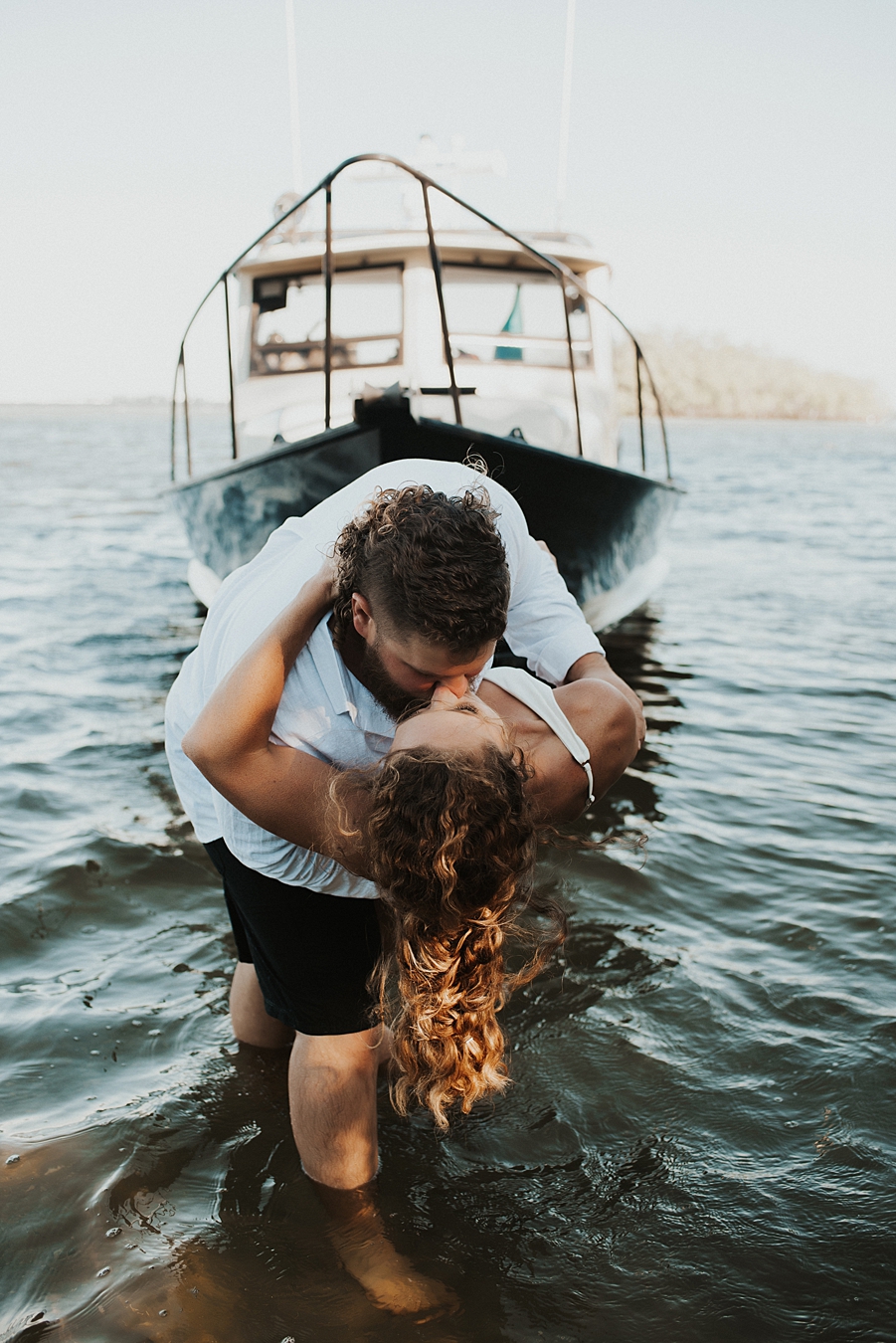 Bride and groom posing in front of fishing boat