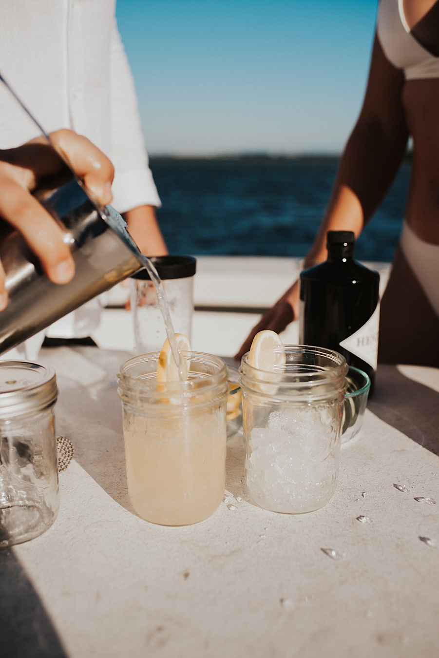 Bride and groom mixing cocktails on boat