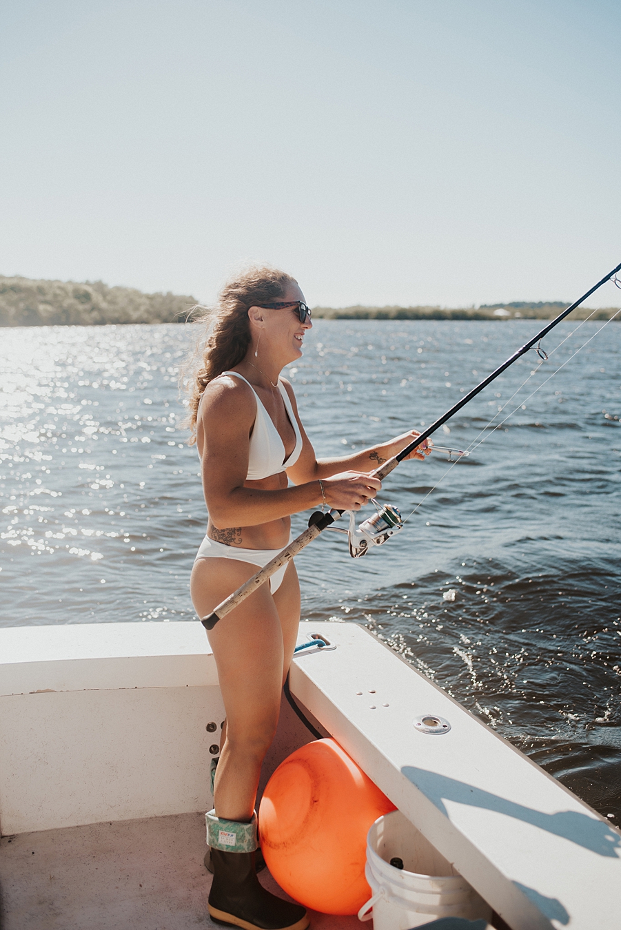 Bride in bikini fishing during elopement