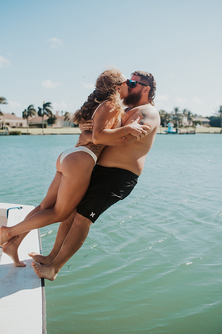 Bride and groom falling into water from side of boat
