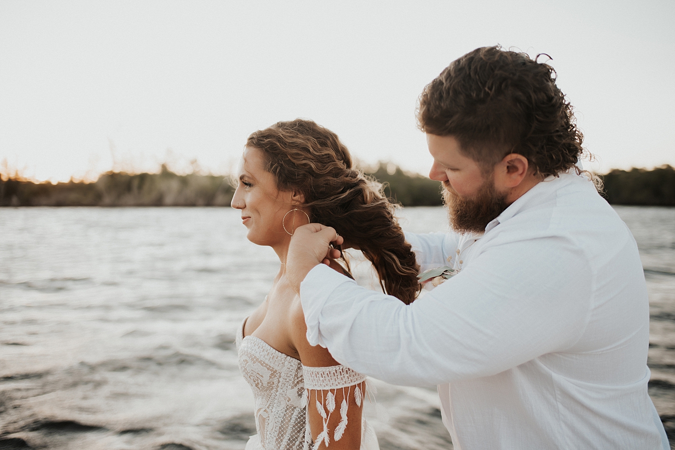 Groom putting on brides necklace during elopement