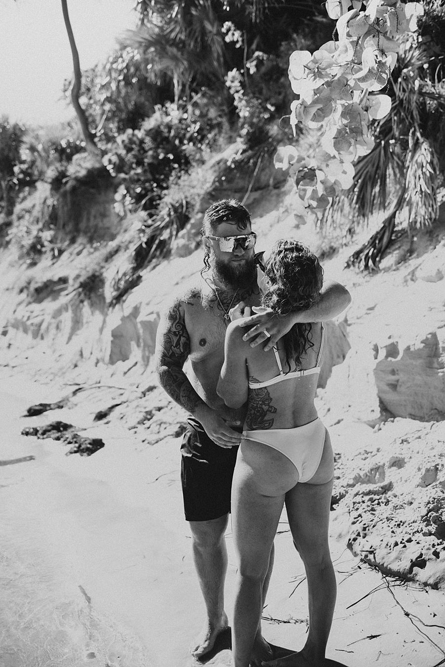 Groom kissing bride in front of sand bar