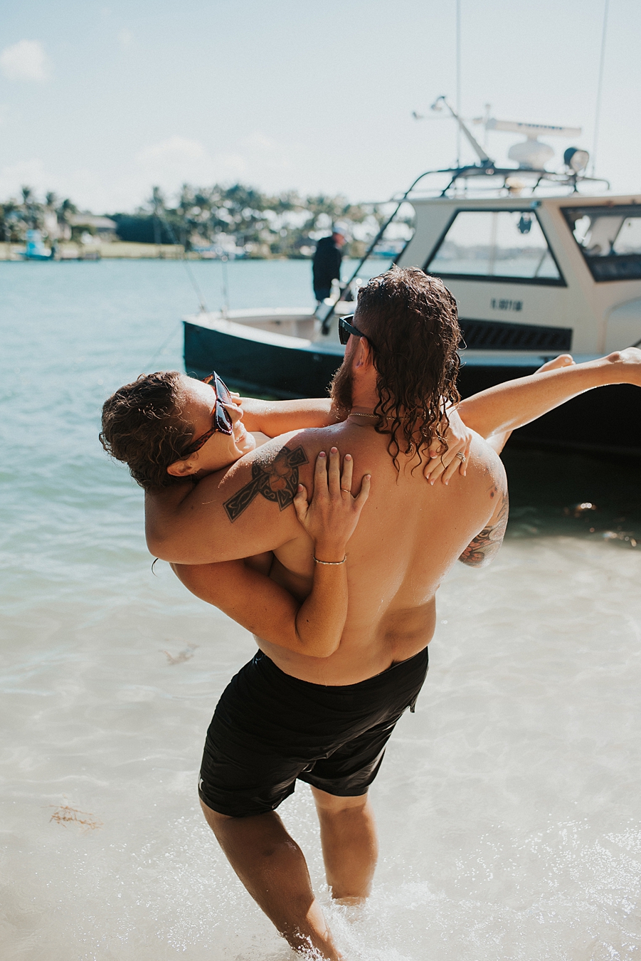 Groom carrying bride into water