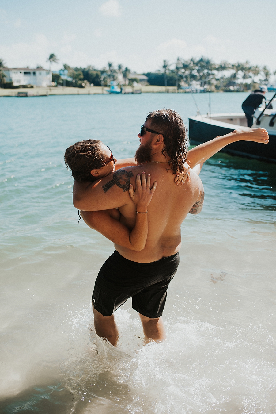 Groom carrying bride into water