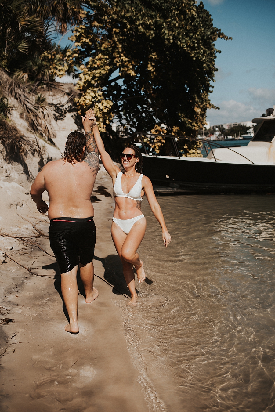 Bride and groom high fiving on beach